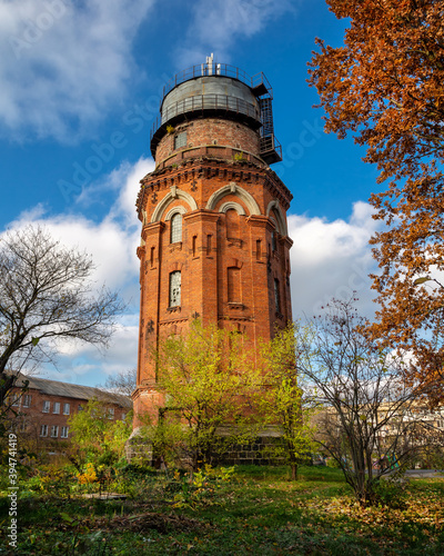 Old water tower in the autumn city. Autumn architecture..