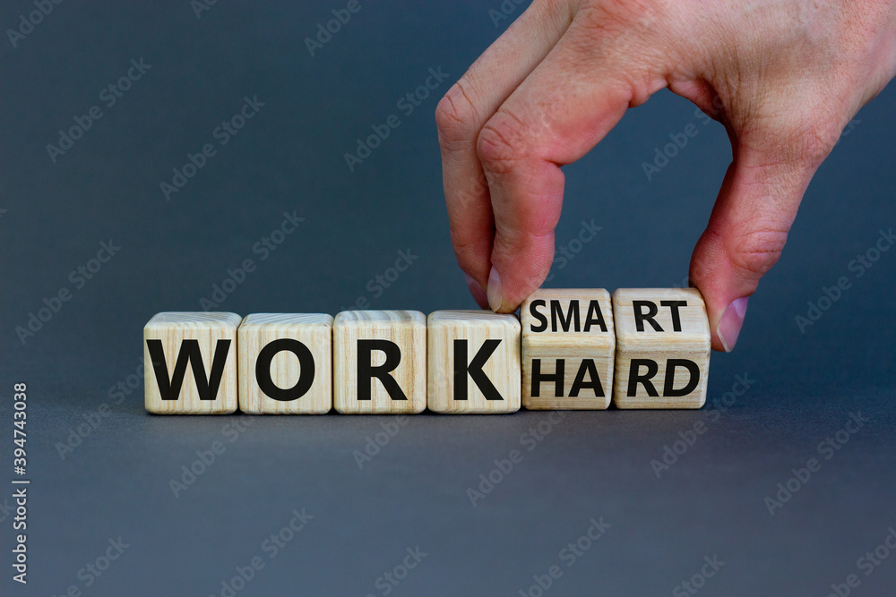 Work hard or work smart. Hand turns cubes and changes the words 'work hard' to 'work smart'. Beautiful grey background. Business and work smarter concept, copy space. - obrazy, fototapety, plakaty 