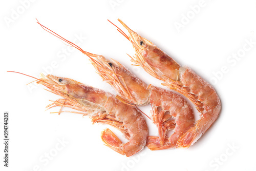 Three frozen, fresh, red langoustines close-up on a white background, seafood