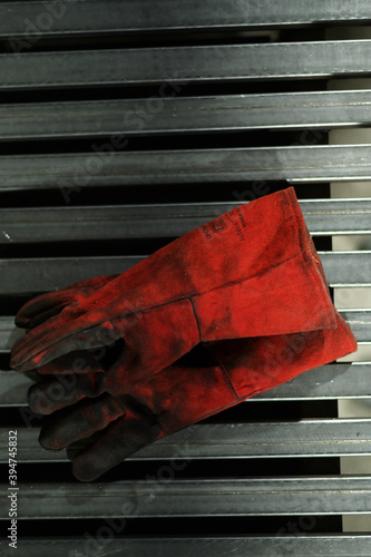 Photo of welding gloves, welder's mask on a metal table in the workshop