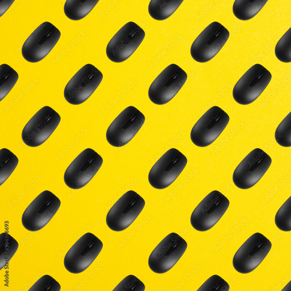 Rows of black plastic optical computer mouses on office table yellow color. Top view. Seamless pattern Rows of black plastic optical computer mouses on office table yellow color. Top view. Seamless pattern