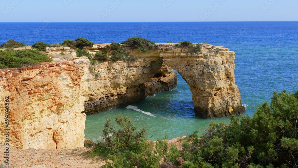 Blick auf einen Felsbogen an der Steilküste der Algarve, Portugal