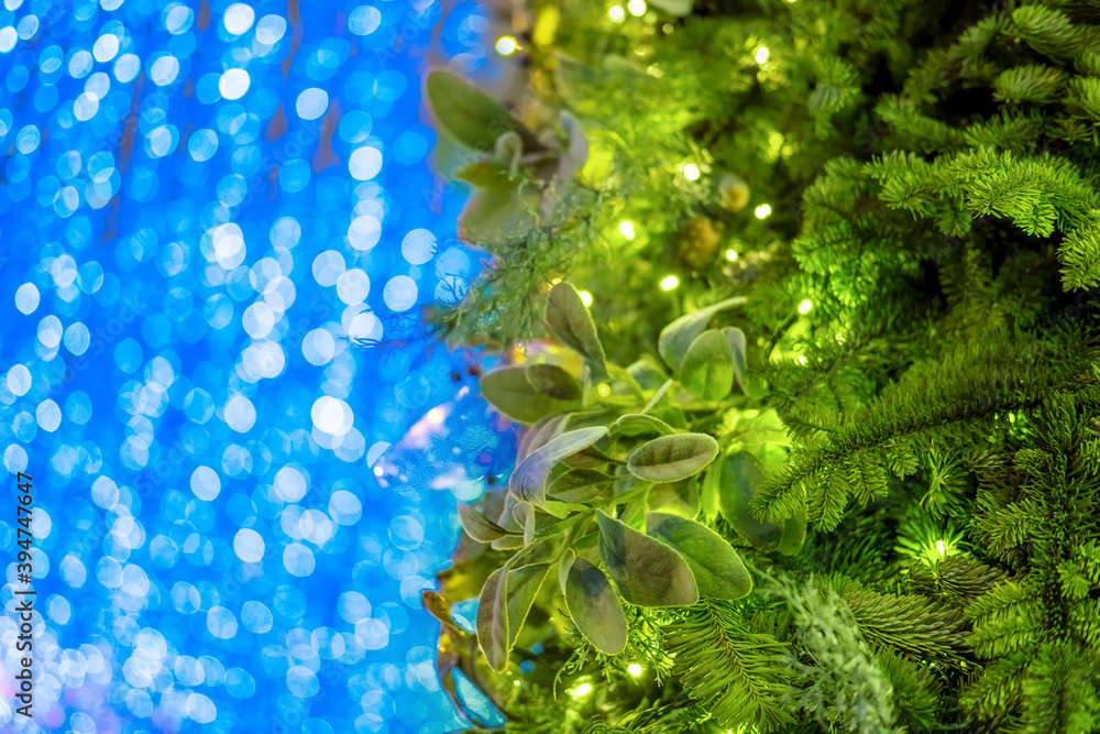 Green Christmas tree and bokeh background of garland blue lights, copy space