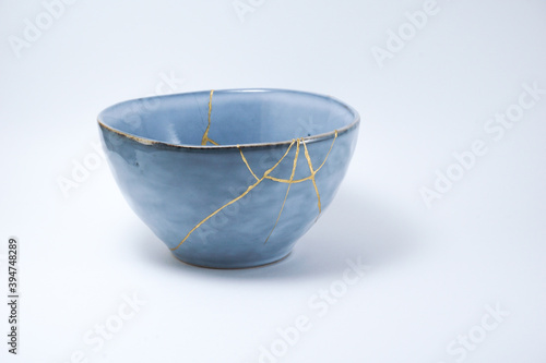 Blue kintsugi bowl. Gold cracks restoration on pottery restored with the antique Kintsugi restoration technique. The beauty of imperfections. representation of trauma. 