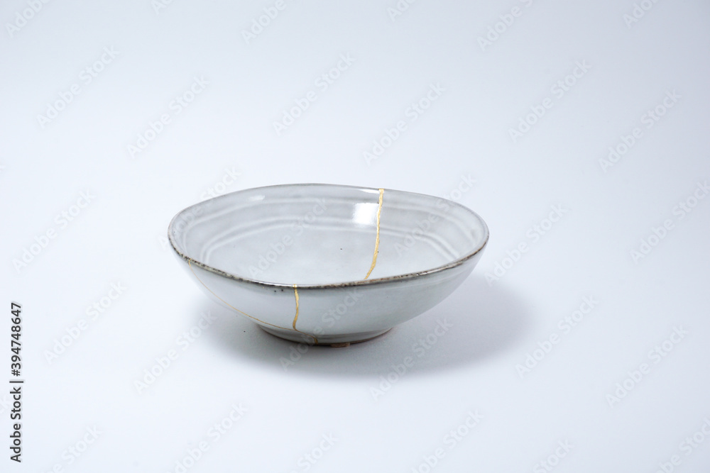 Kintsugi Japanese grey bowl. Gold cracks restoration on pottery restored with the antique Kintsugi restoration technique. The beauty of imperfections. representation of trauma. Kintsugi Japanese grey bowl. Gold cracks restoration on pottery restored with the antique Kintsugi restoration technique. The beauty of imperfections. representation of trauma.