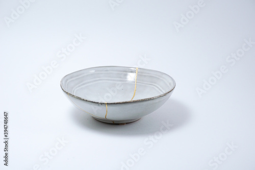 Kintsugi Japanese grey bowl. Gold cracks restoration on pottery restored with the antique Kintsugi restoration technique. The beauty of imperfections. representation of trauma. 