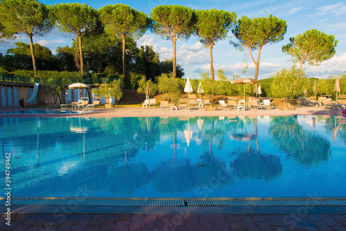 An empty hotel swimming pool in Tuscany, Italy, in the late afternoon sun 