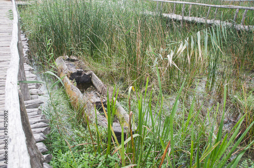 Old wooden boat near a wooden deck made of logs