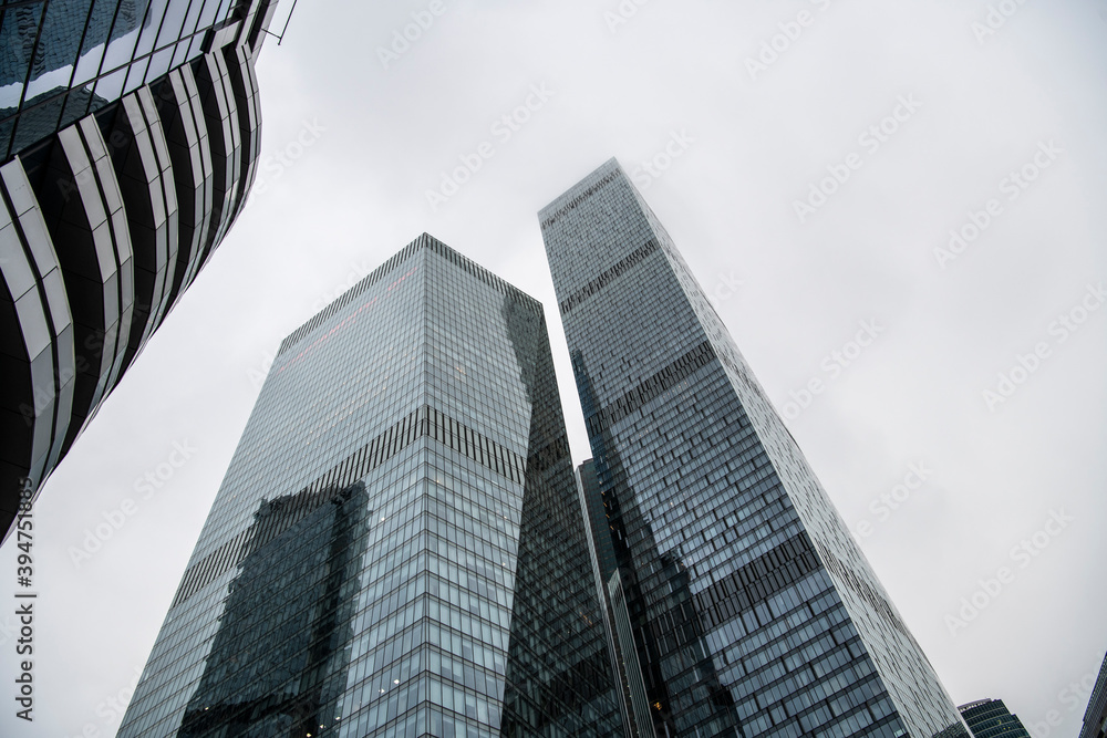 Obraz premium mesmerizing geometry of skyscrapers receding into the clouds against a gray sky