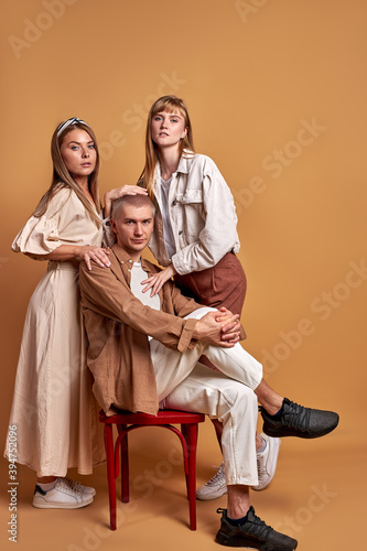 unusual group of extraordinary youth posing in trendy wear, caucasian models confidently look at camera isolated in studio