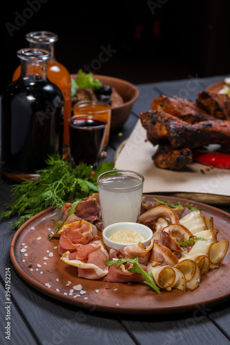 Bacon and lard on a plate. with grilled pork ribs, and wine on black wooden background