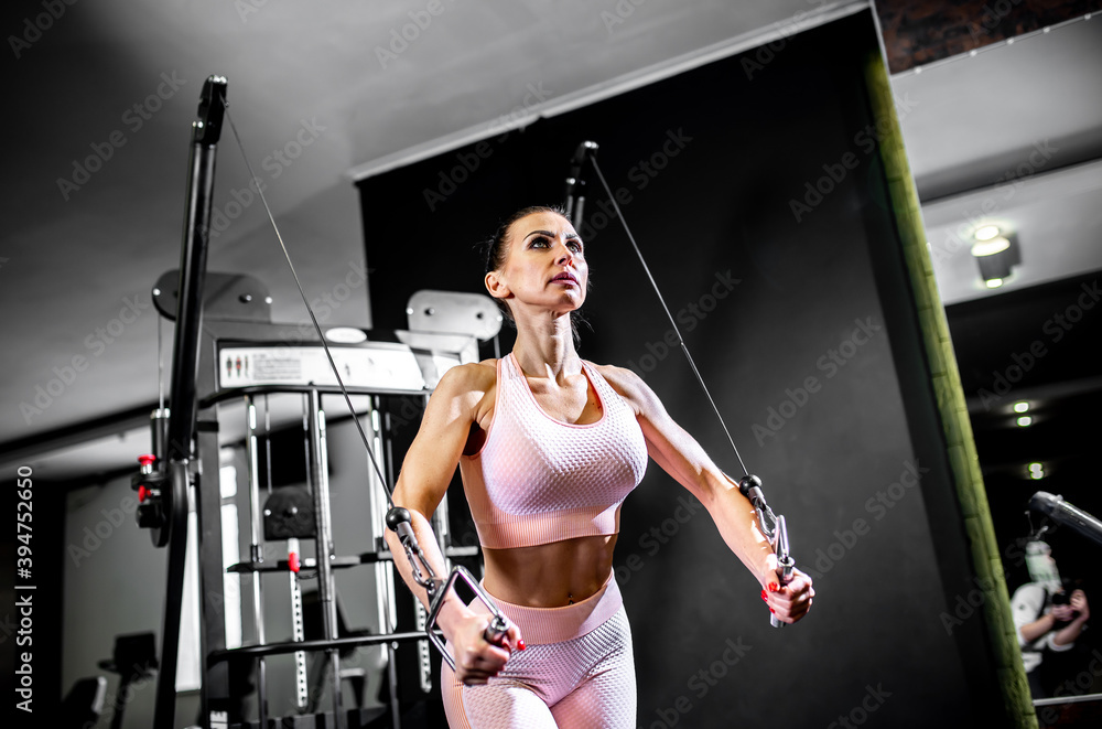A girl in sportswear in a professional gym works out with fitness equipment. Healthy lifestyle concept A girl in sportswear in a professional gym works out with fitness equipment. Healthy lifestyle concept