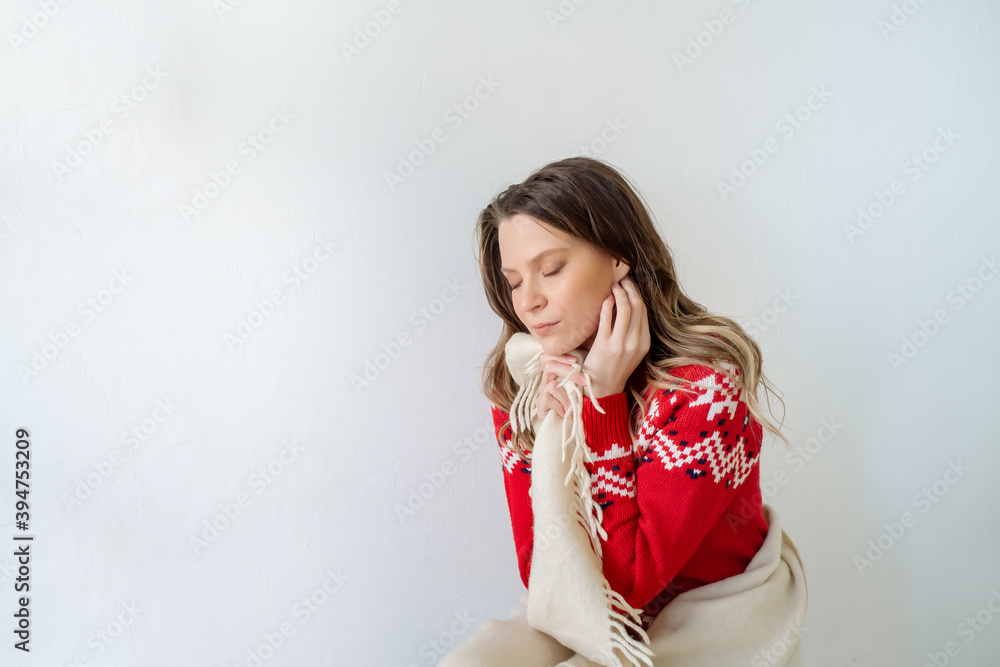 A young Caucasian woman with long curly hair in a New Year's sweater is wrapped in a plaid and is freezing in the cold season. Isolated on white background
A young Caucasian woman with long curly hair in a New Year's sweater is wrapped in a plaid and is freezing in the cold season. Isolated on white background