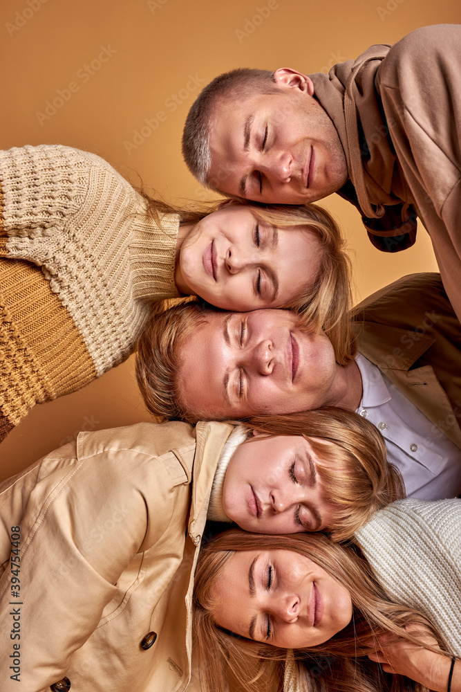 group of sleepy young people on each other, portrait of males and females in coats relaxing group of sleepy young people on each other, portrait of males and females in coats relaxing