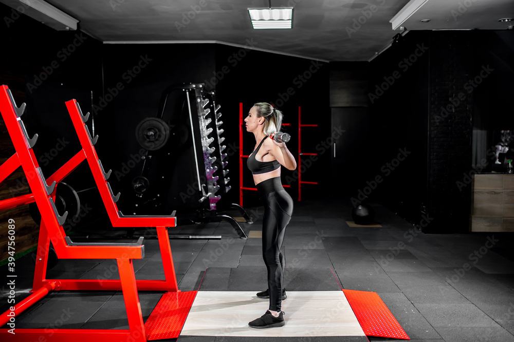 Obraz premium Young girl lifting weights in the gym. healthy lifestyle concept