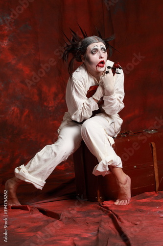 The art of depression. Studio portrait of young female actress performing as an old clown. Depresson and isolation concept photo