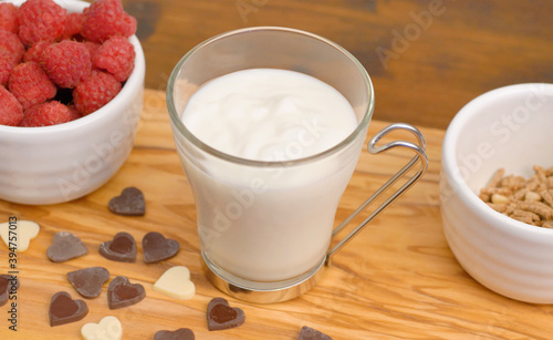 white yogurt with honet, cereal grain and fresh raspberries photo