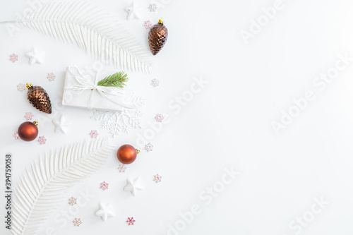 Flat lay frame with christmas baubles decoration, snowflakes and gift box on a white background