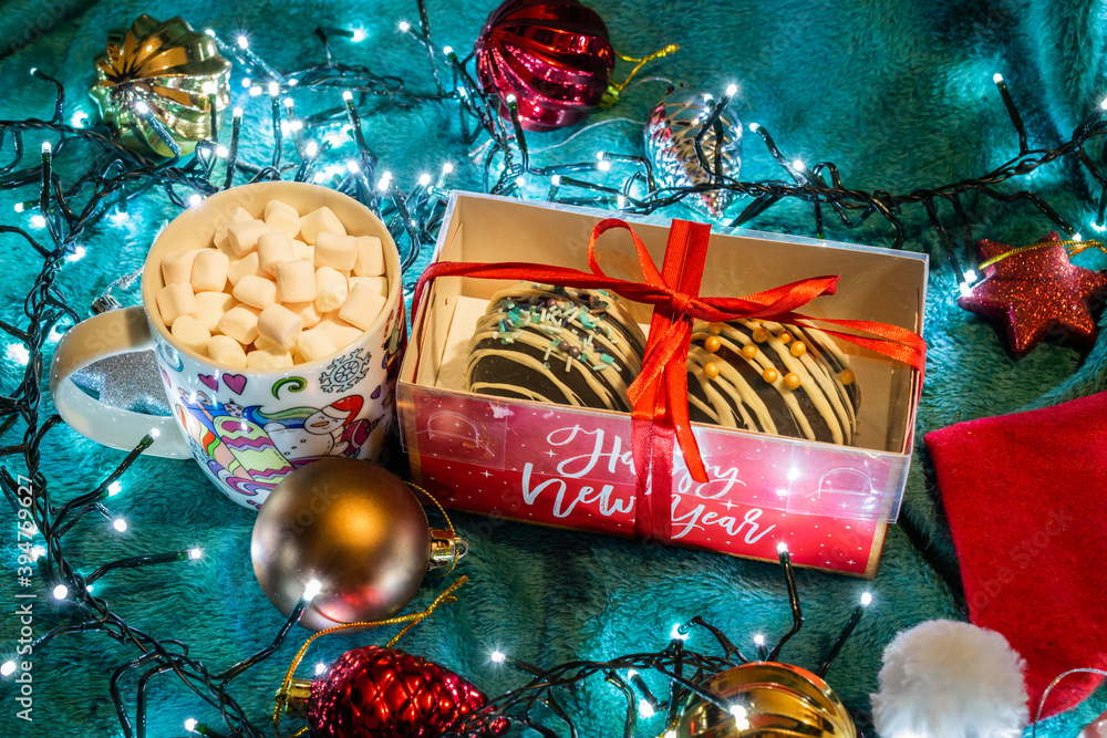 Set of chocolate bombs in cristmas giftbox with mini marshmallows, white chocolate, milk chocolate and hot cocoa, ingredients that melts with hot milk. Delicious winter holidays dessert with xmas toys