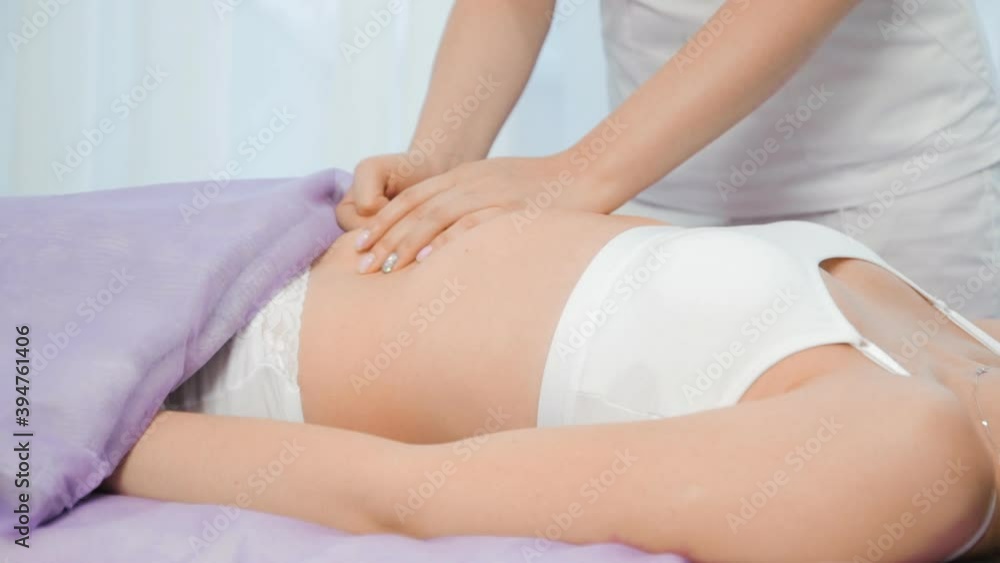 Young woman having massage in spa salon. Close-up of woman relaxing during back massage lying on massage table Young woman having massage in spa salon. Close-up of woman relaxing during back massage lying on massage table