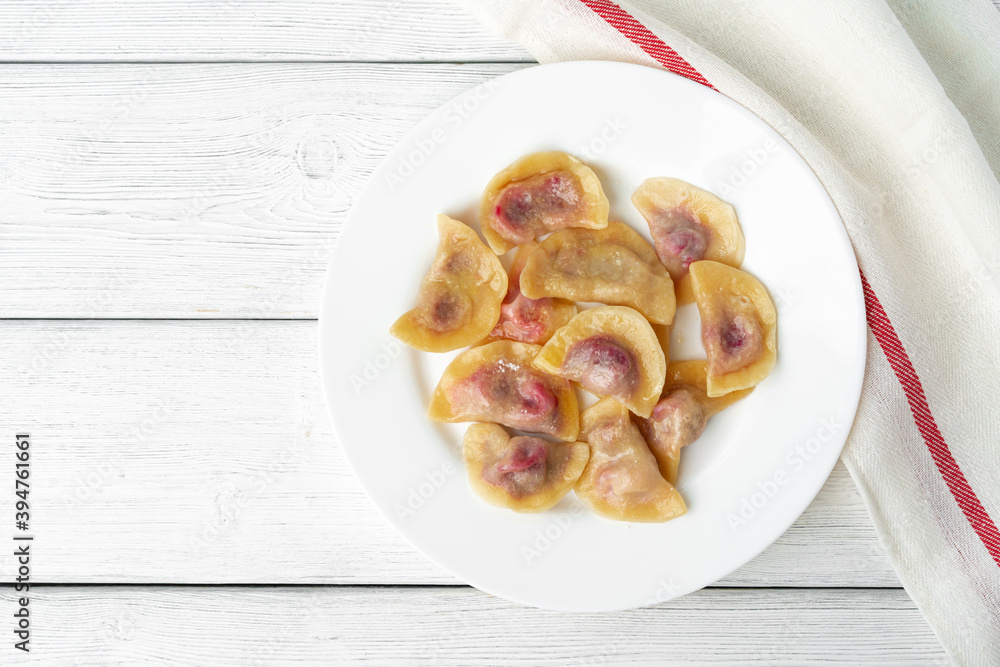 Russian dumplings on white plate on white wooden table Russian dumplings on white plate on white wooden table