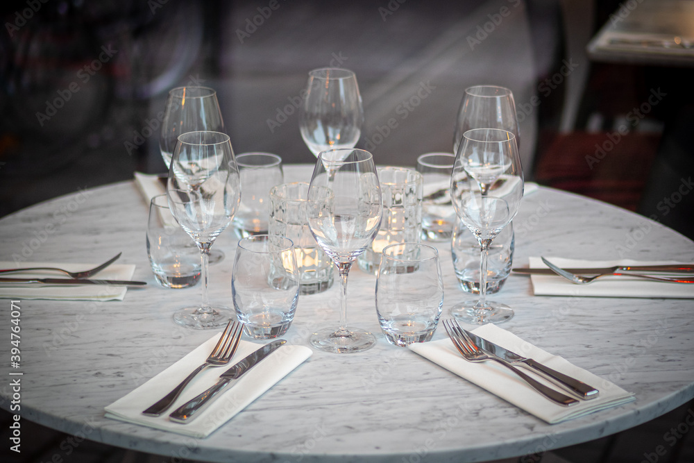 Empty round restaurant table with wine glasses and candles 