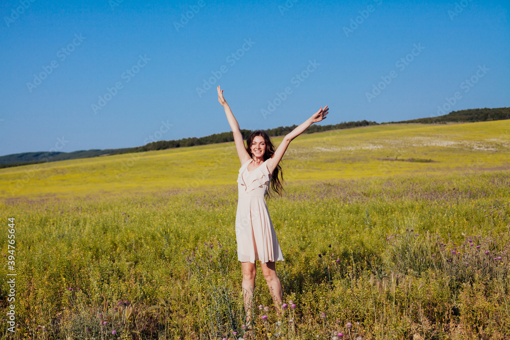 Beautiful woman in dress walks on the field happily one Beautiful woman in dress walks on the field happily one