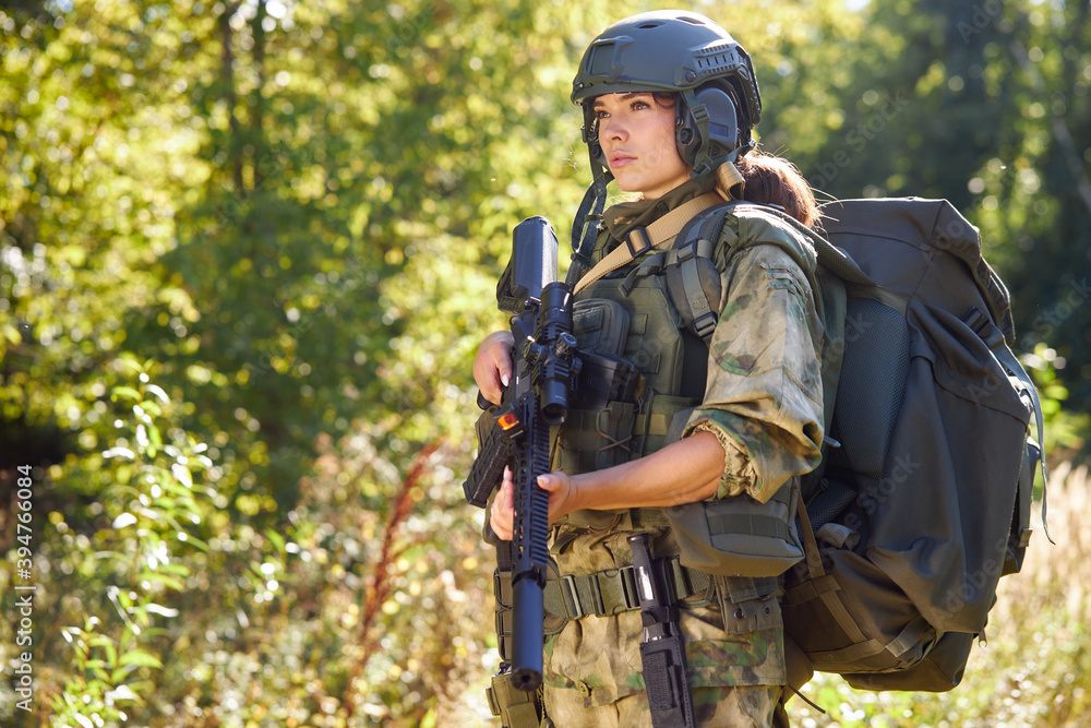 powerful sportive woman soldier ready for battle wearing protective military gear weapon, rifle or gun. in wild nature powerful sportive woman soldier ready for battle wearing protective military gear weapon, rifle or gun. in wild nature