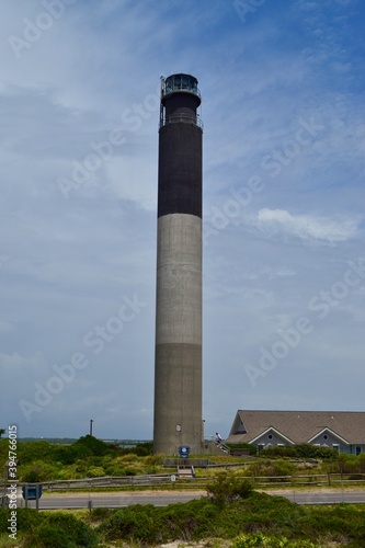 Striped lighthouse looks out to the North Carolina coast. Tall cement built light on the beach.