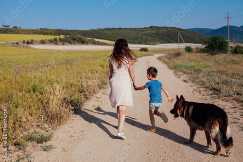 Mom and son walk with German Shepherd