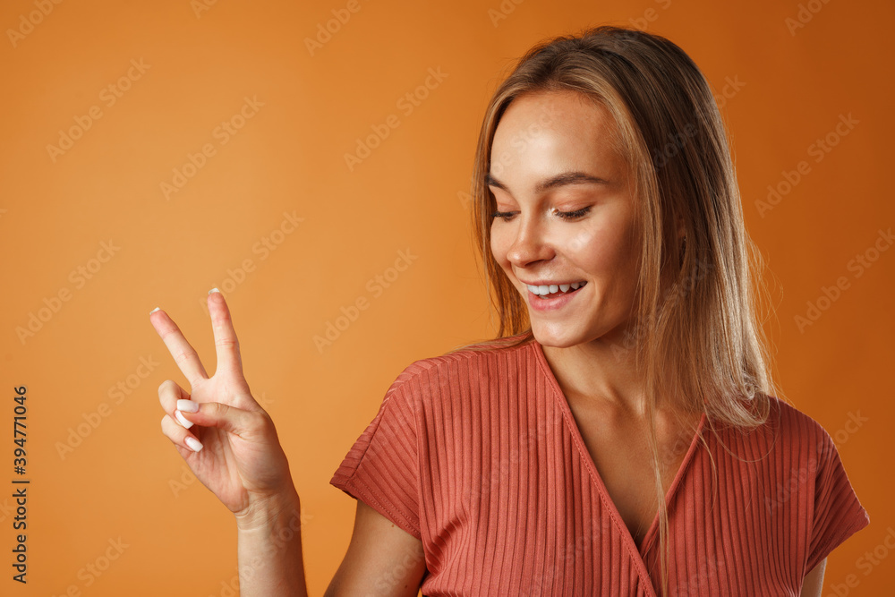Young happy smiling woman showing victory sign. Young happy smiling woman showing victory sign.