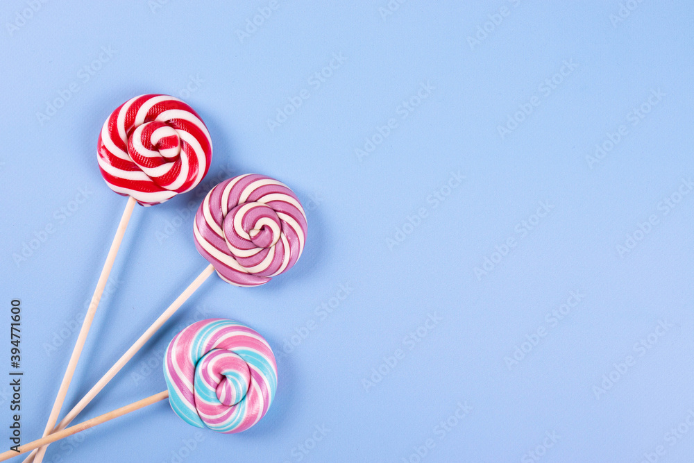 sweet yummy festive colorful lollipops on light blue background. copy space for text. minimalism style sweet yummy festive colorful lollipops on light blue background. copy space for text. minimalism style