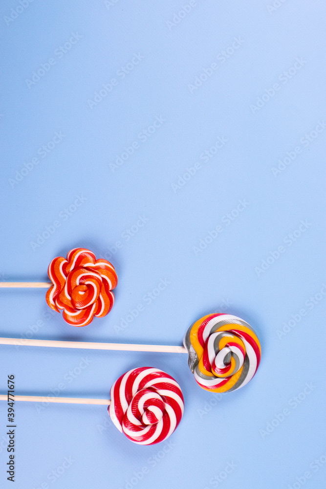 sweet yummy festive colorful lollipops on light blue background. copy space for text. minimalism style sweet yummy festive colorful lollipops on light blue background. copy space for text. minimalism style