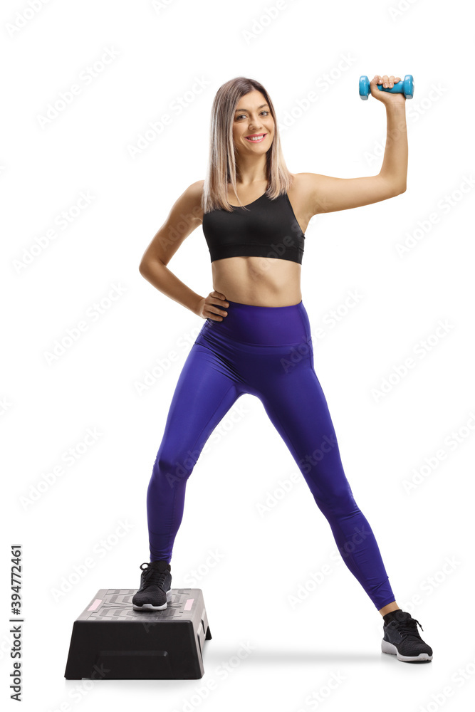 lond female in sportswear exercising step aerobic with a dumbbell lond female in sportswear exercising step aerobic with a dumbbell