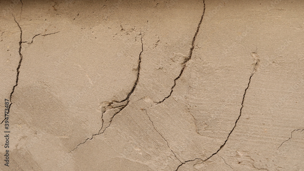 light brown wall with cracks in plaster, textured stucco background of old surface