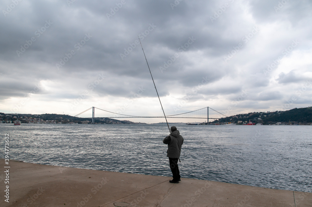Man fishing in the Bosphorus during the winter.