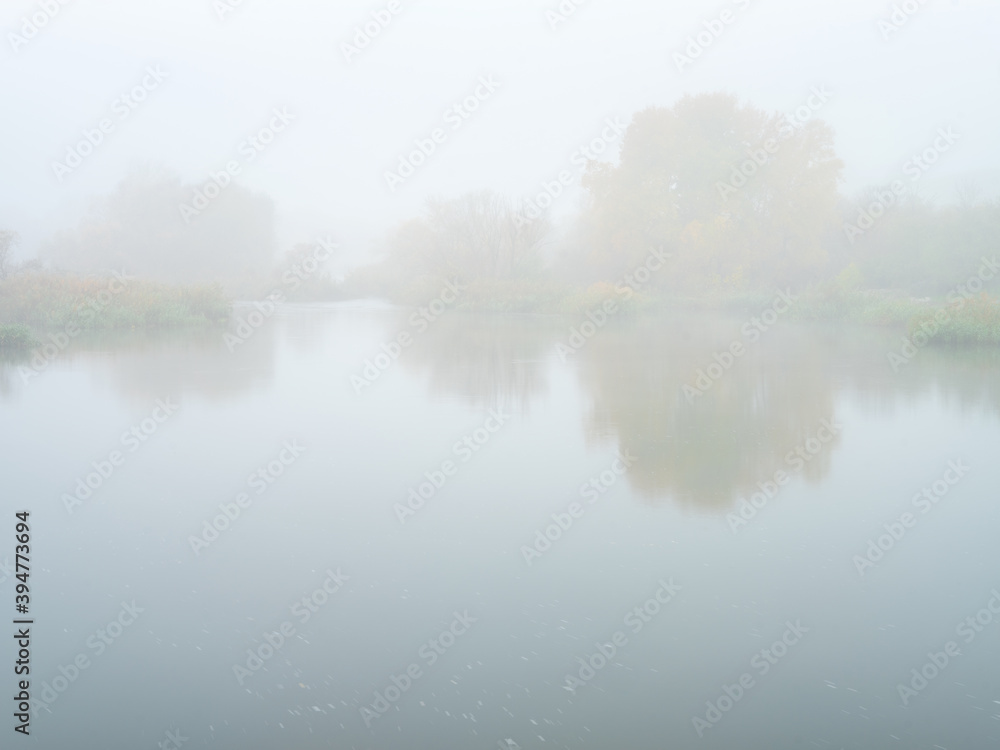 view to fully foggy morning on the river in autumn day with copy space