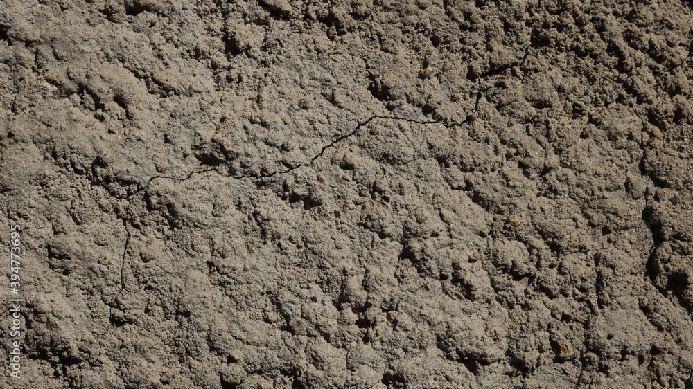 deep gray dry concrete surface with fine cracks in the structure and relief texture of irregularities deep gray dry concrete surface with fine cracks in the structure and relief texture of irregularities