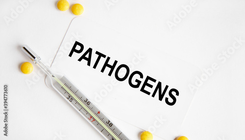 On the business card the text of PATHOGENS, next to the thermometer and yellow tablets.