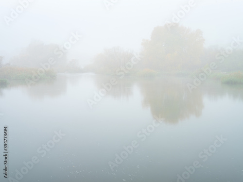 view to fully foggy morning on the river in autumn day with copy space