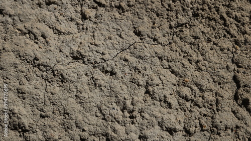 deep gray dry concrete surface with fine cracks in the structure and relief texture of irregularities