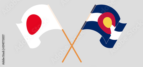 Crossed and waving flags of Japan and The State of Colorado