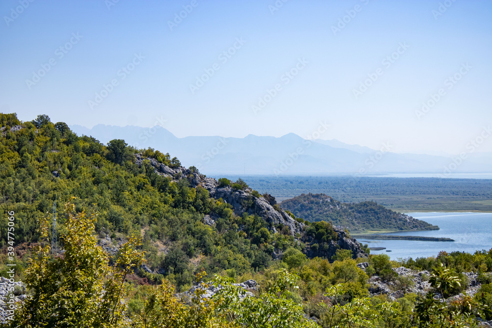 A beautiful view of the Skadar (Skoderskoe) lake among the mountains. This section of the lake is overgrown with tall grass. Montenegro. 