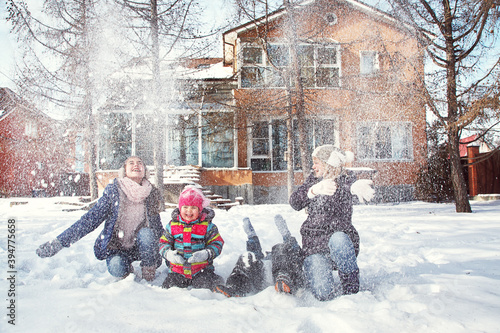 family playing with snow in the winter outdoors