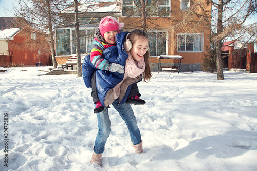 children playing in the yard of his house in the winter outdoors