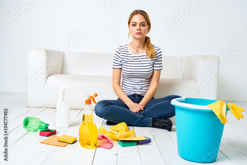Cleaning lady with bucket of washing supplies on the floor interior housework 