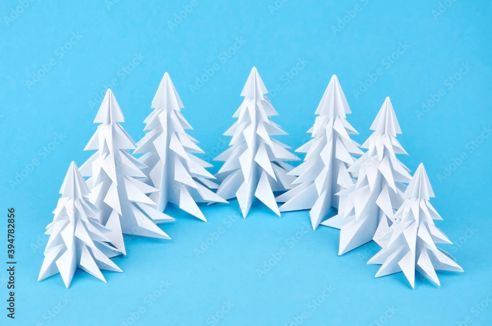 Obraz premium White paper origami christmas trees on blue background
