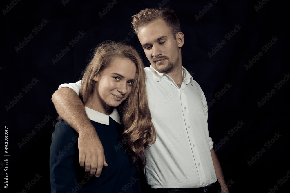 Young beautiful couple studio portrait on black background. Young beautiful couple studio portrait on black background.