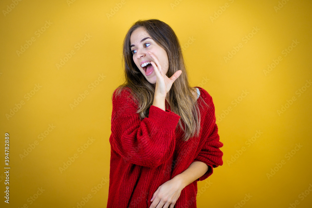 Young beautiful woman wearing red sweater over isolated yellow background hand on mouth telling secret rumor, whispering malicious talk conversation Young beautiful woman wearing red sweater over isolated yellow background hand on mouth telling secret rumor, whispering malicious talk conversation