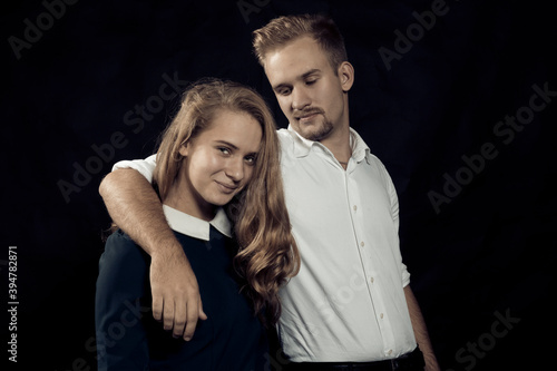 Young beautiful couple studio portrait on black background. © idea_studio